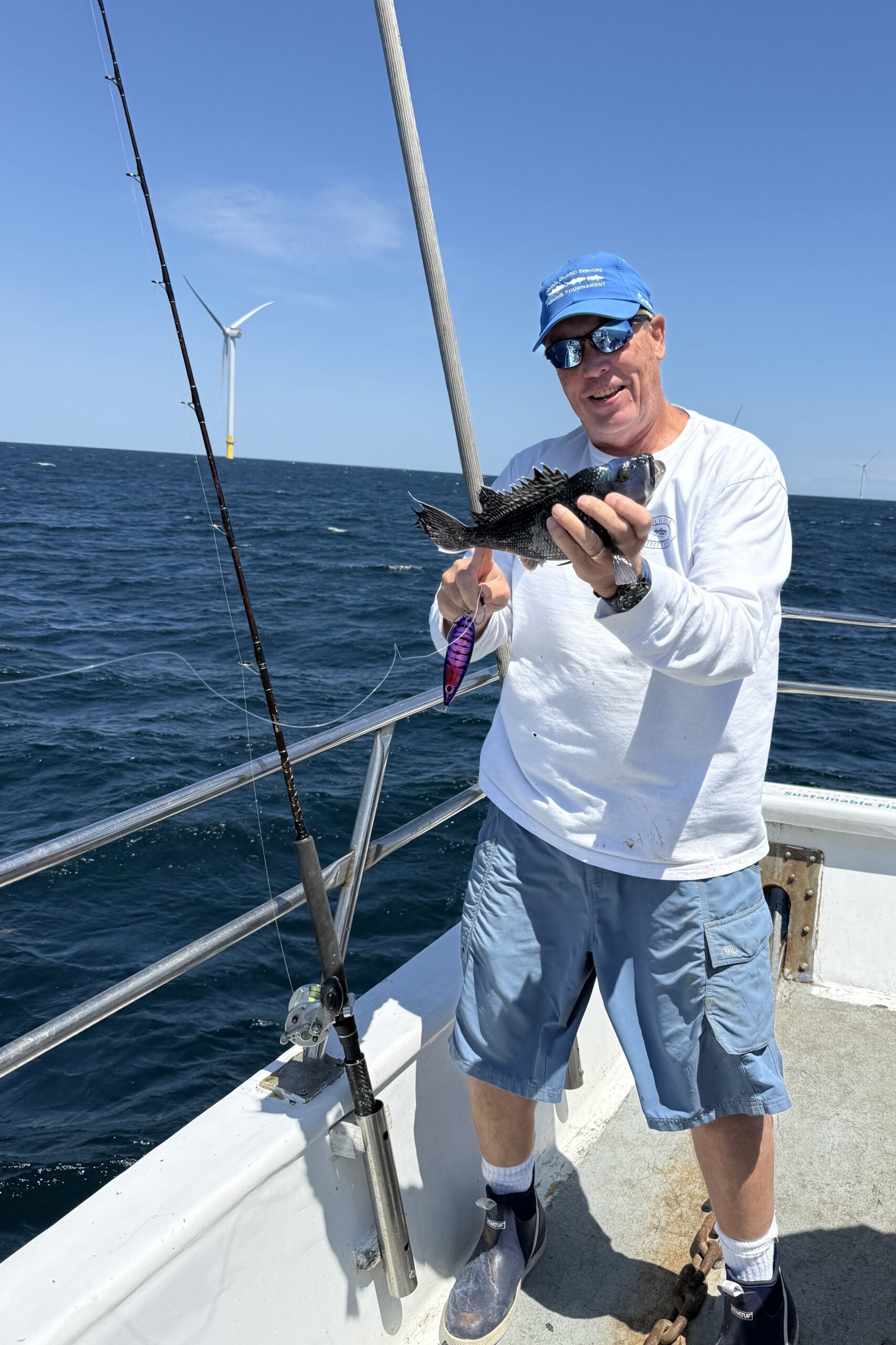 An angler holding up his catch, a black sea bass